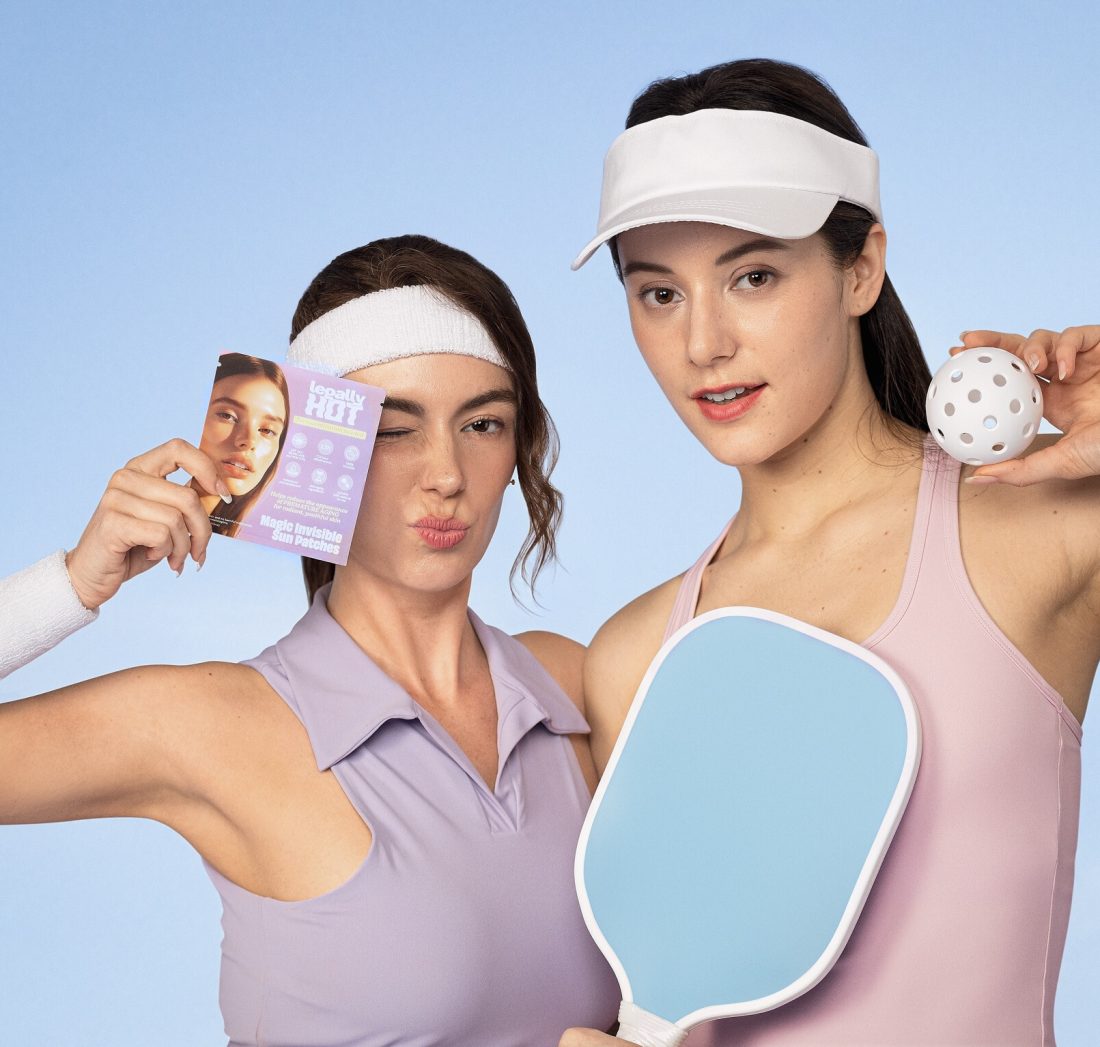 Two women on a pickleball court with Legally Hot Magic Invisible Sun Patches